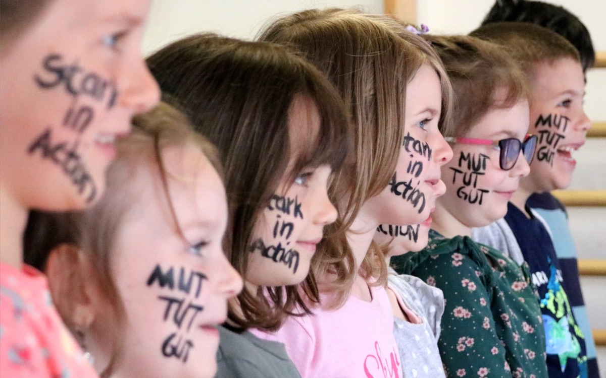 Kinder mit „Mut tut gut“ auf der Wange
